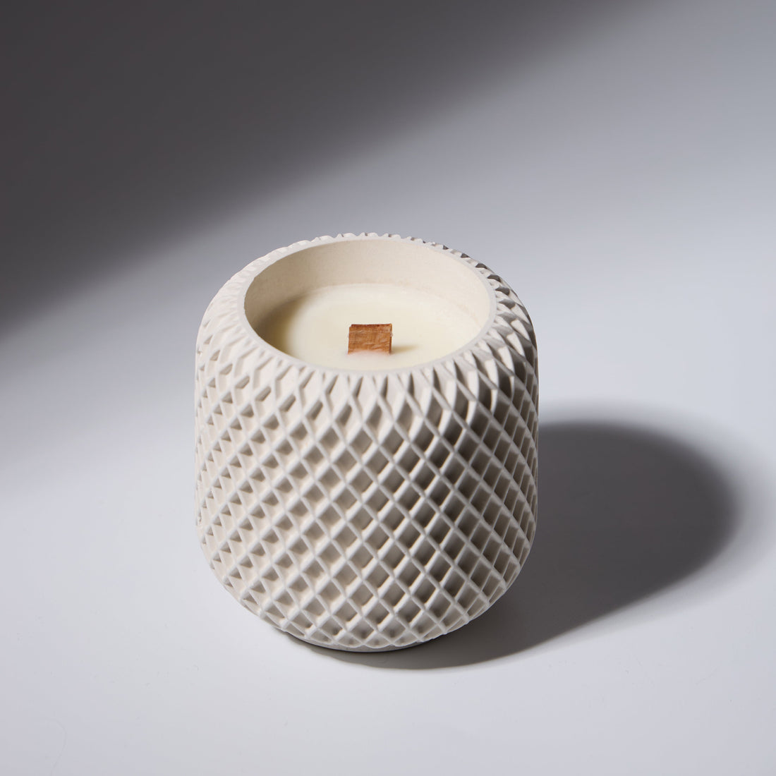 Soy candle in a concrete container with a wooden wick